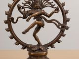 a bronze statue of the hindu god shiva on a wooden table