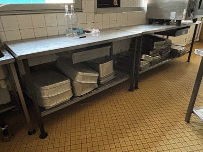une grande cuisine avec un plan de travail en métal et une étagère en métal