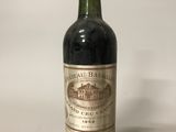 une vieille bouteille de vin posée sur une table blanche