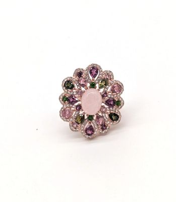 une image représentant une bague rose et verte posée sur une surface blanche