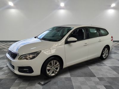 une voiture blanche est garée dans une pièce au sol à carreaux