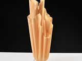 a vase that has folded paper in it on a table