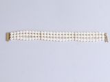 a close up of a white pearl bracelet on a white surface