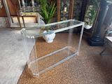 a clear glass table with a vase on top of it