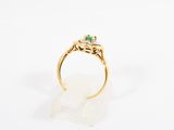 a gold ring with an emerald stone and diamonds