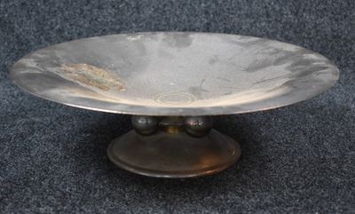 une image représentant une assiette en argent posée sur un tapis bleu