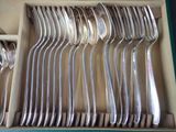 a lot of silver spoons and forks in a box