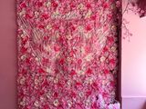 un grand mur recouvert de fleurs roses dans une pièce ornée d'un lustre