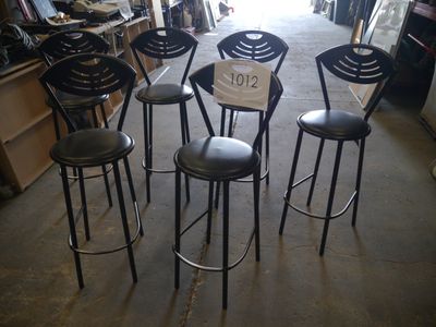 four black stools in a room with a price tag on them