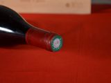 a bottle of wine sitting on a red table cloth