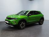 Un SUV vert est garé dans une grande pièce.