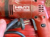 someone is holding a drill in a red box with a cord