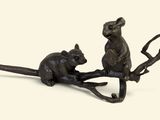 a bronze figurine of a mouse and a rat on a branch