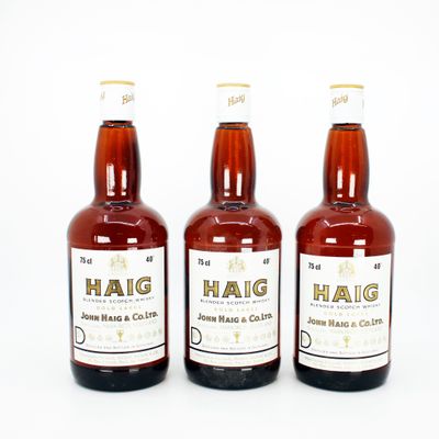 trois bouteilles de bière posées les unes à côté des autres sur une surface blanche