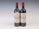 deux bouteilles de vin rouge posées l'une à côté de l'autre sur une surface blanche