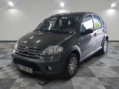 a picture of a small grey car parked in a garage