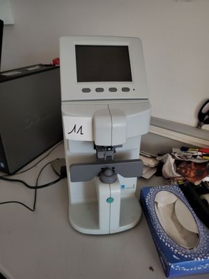 a machine that is sitting on a desk next to a laptop