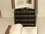 un livre ouvert sur une table, à côté d'une pile de livres