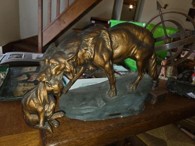a bronze statue of a dog and a cat on a table