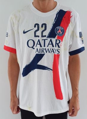 Cet homme porte une chemise blanche ornée d'un motif rouge, bleu et blanc.