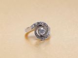 une bague en argent sertie d'un diamant, posée sur une table
