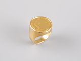a gold coin ring on a white surface