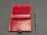 wallet and pen on a table next to a pen on a table