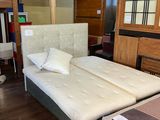 two beds that are in a room with wood floors