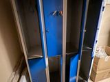 three blue lockers in the corner of a room