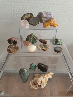 une table en verre transparent sur laquelle sont posés des cailloux et des œufs