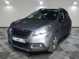 une voiture grise garée dans une pièce au sol à carreaux et aux murs blancs