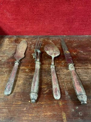 cinq cuillères et un couteau posés sur une table en bois