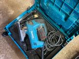 une boîte à outils bleue, contenant des outils, posée par terre