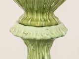 a green vase that is sitting on top of a table