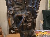 un vase en bronze posé sur une table sur laquelle se trouve une assiette