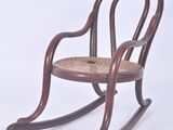 a wooden rocking chair with a wicker seat on it
