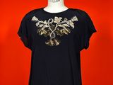 a woman ' s black top with a gold tree on it