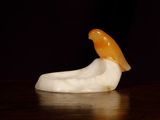 an orange and white bird figurine sitting on a table