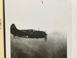 a black and white photo of an old airplane flying in the sky