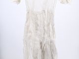 an image of a white dress hanging on a hanger in a room