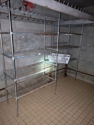 une étagère métallique au milieu d'une pièce, sur laquelle se trouve un panier