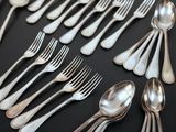 a lot of silver spoons and forks on the table