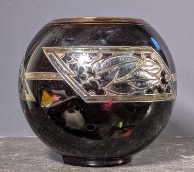a black vase with a silver design on it