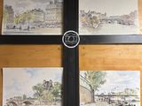 trois aquarelles représentant une ville avec une horloge accrochée au mur