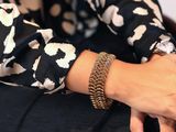 La femme porte un t-shirt noir et blanc et un bracelet.