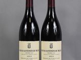 deux bouteilles de vin posées sur une table l'une à côté de l'autre