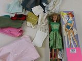 beaucoup de vêtements et une poupée dans une boîte posée sur une table