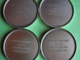 four tins of chocolate sitting on top of a green surface