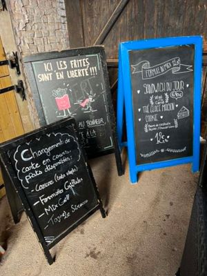 trois tableaux noirs posés les uns à côté des autres sur le sol