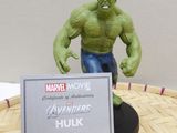 a statue of hulk on a table with a sign in front of it